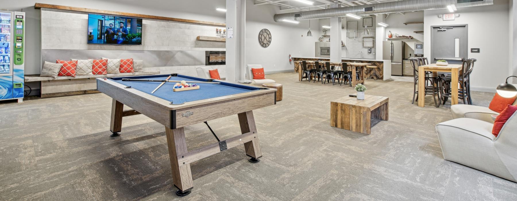 a room with a pool table and chairs