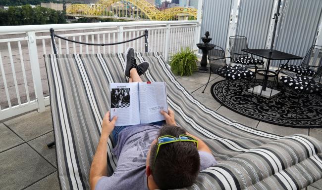 a person lying on a deck reading a book
